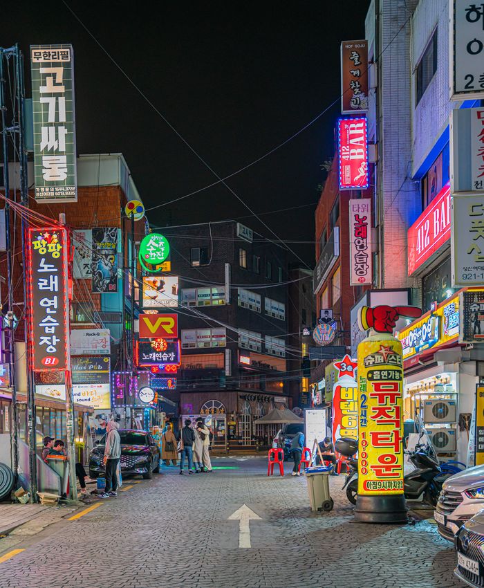 Explore Seoul's bustling nightlife with neon signs and vibrant streetscapes, capturing the city's lively atmosphere.